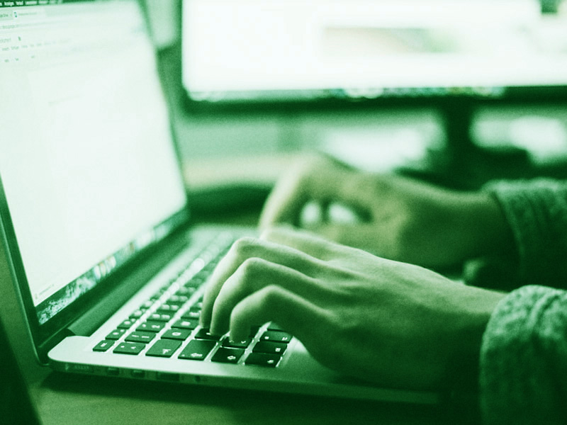 Close up of hands using keyboard of a laptop